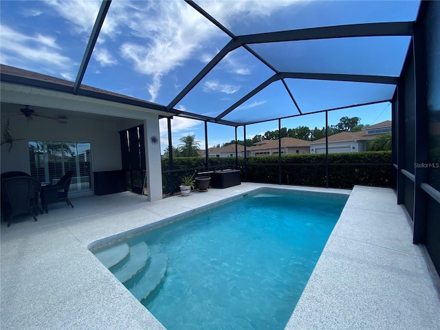 view of pool featuring a patio, ceiling fan, and glass enclosure