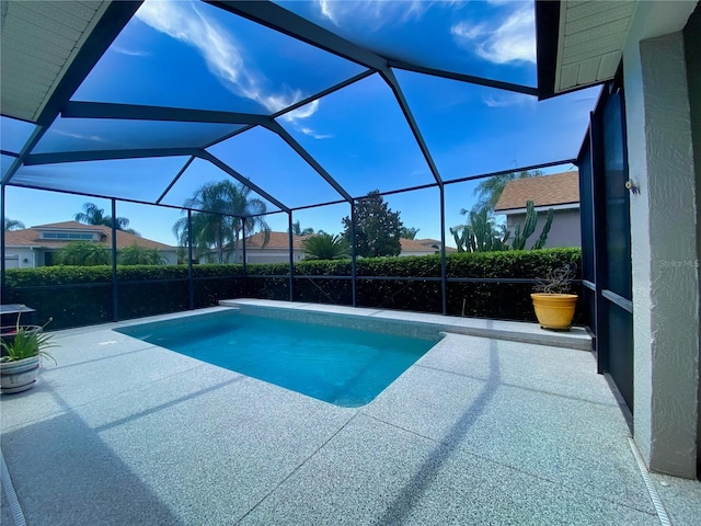 view of swimming pool with a patio area and a lanai