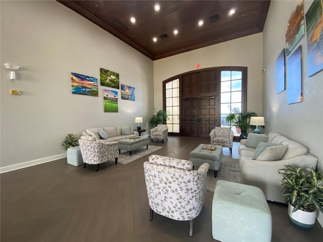 living room with dark wood-type flooring, a towering ceiling, and wooden ceiling