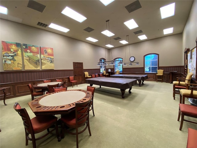 rec room with light carpet, wooden walls, billiards, and a high ceiling