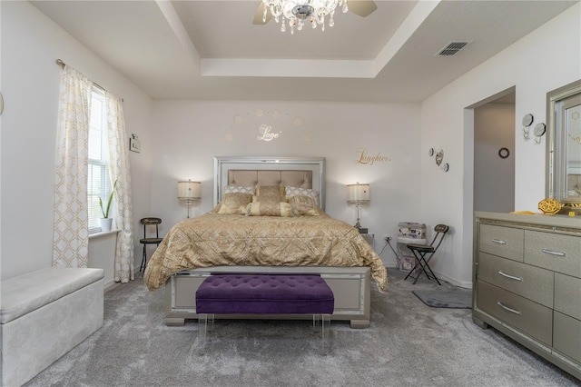 bedroom with ceiling fan, carpet flooring, and a raised ceiling