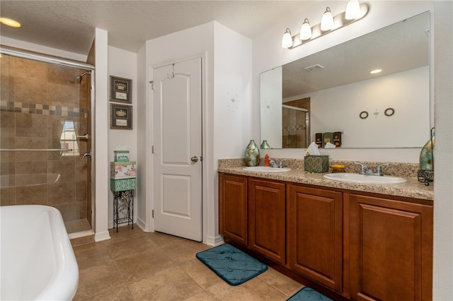 bathroom featuring vanity, separate shower and tub, a textured ceiling, and tile patterned floors