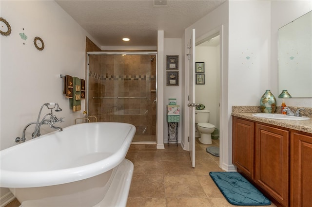 full bathroom featuring vanity, toilet, a textured ceiling, and separate shower and tub