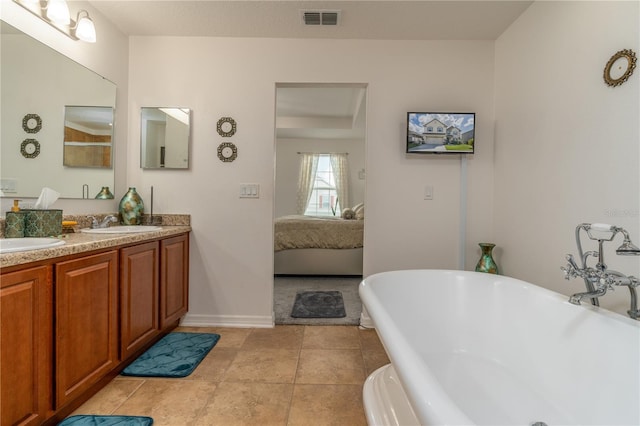 bathroom with a bathtub, tile patterned flooring, and vanity