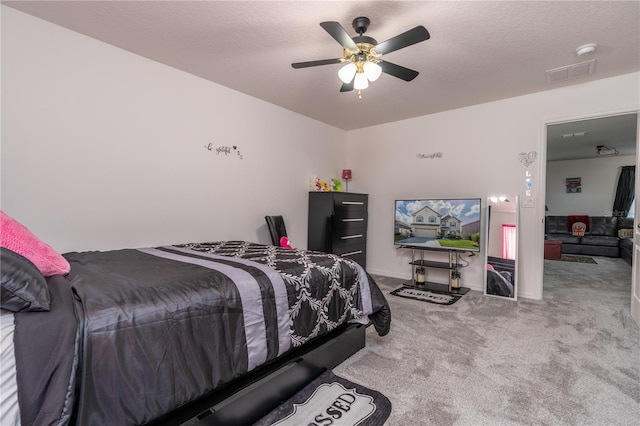 bedroom featuring a textured ceiling, carpet floors, and ceiling fan