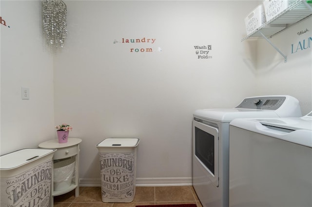 clothes washing area with dark tile patterned floors and washing machine and dryer