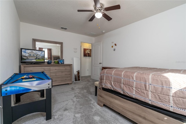 carpeted bedroom with a textured ceiling and ceiling fan