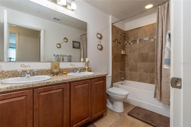 full bathroom with a textured ceiling, toilet, shower / bath combo, vanity, and tile patterned flooring