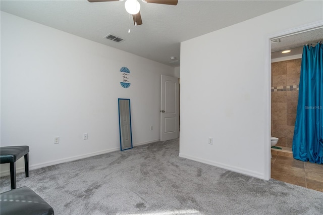 carpeted empty room with a textured ceiling and ceiling fan