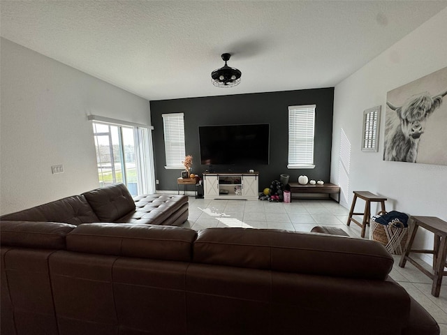 living room with a textured ceiling and light tile patterned flooring