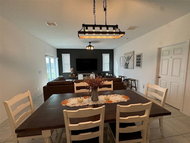 dining room featuring a textured ceiling and light tile patterned flooring