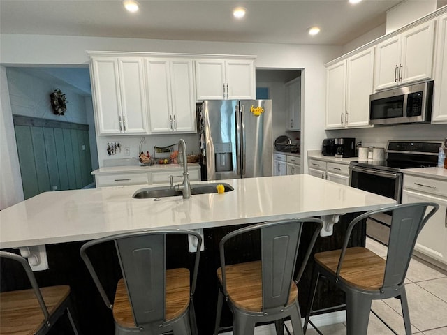 kitchen featuring white cabinetry, a kitchen island with sink, stainless steel appliances, and sink