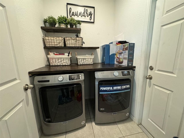 laundry area featuring washing machine and dryer and light tile patterned floors