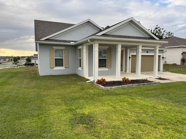 view of front of home featuring a front lawn, covered porch, and a garage