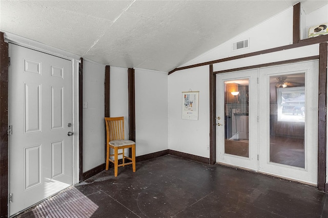 empty room with lofted ceiling and a textured ceiling