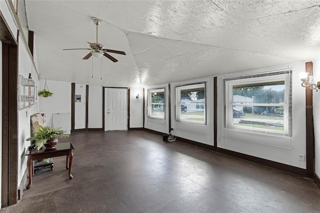 interior space featuring vaulted ceiling, a textured ceiling, and ceiling fan