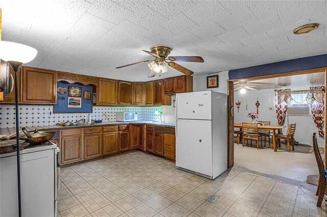 kitchen featuring white appliances, ceiling fan, tasteful backsplash, and sink