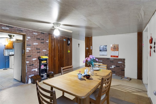 dining room featuring brick wall