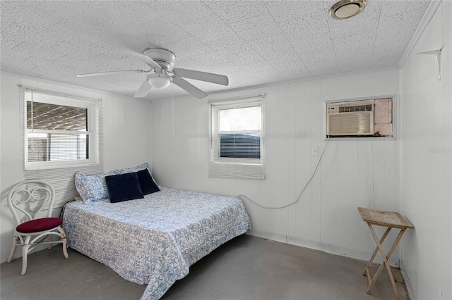 bedroom with ceiling fan, an AC wall unit, and concrete flooring