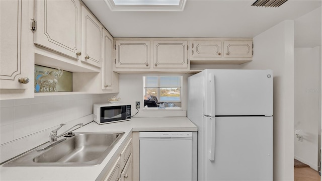 kitchen with white cabinets, white appliances, sink, and tasteful backsplash