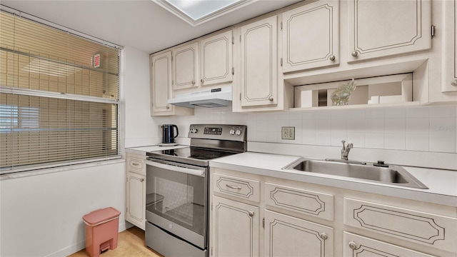 kitchen with decorative backsplash, sink, and electric stove