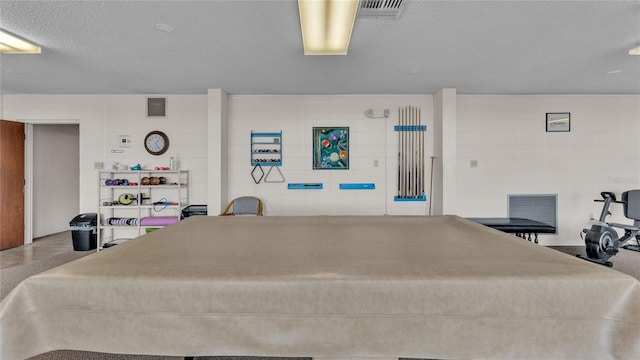 bedroom with a textured ceiling and billiards