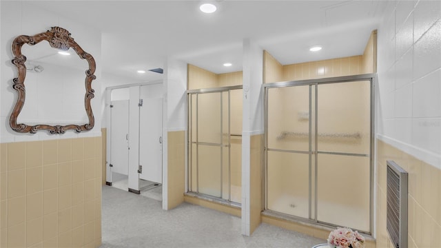 bathroom featuring tile walls and walk in shower