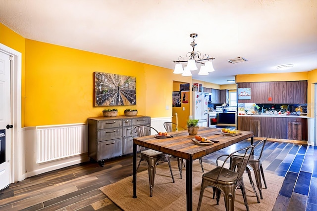 dining space featuring dark hardwood / wood-style floors and a chandelier