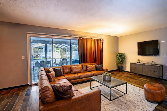 living room featuring dark wood-type flooring and a textured ceiling