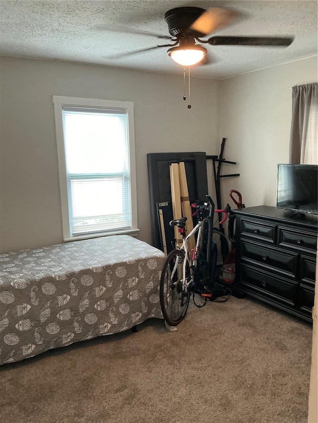 bedroom with a textured ceiling, carpet, and ceiling fan