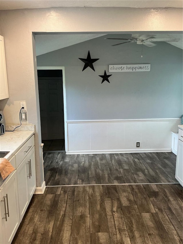 unfurnished dining area with dark wood-type flooring, ceiling fan, and vaulted ceiling