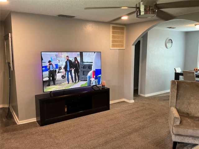 carpeted home theater with ceiling fan and a textured ceiling