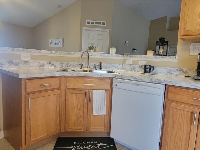 kitchen with lofted ceiling, dishwasher, sink, and light tile patterned floors