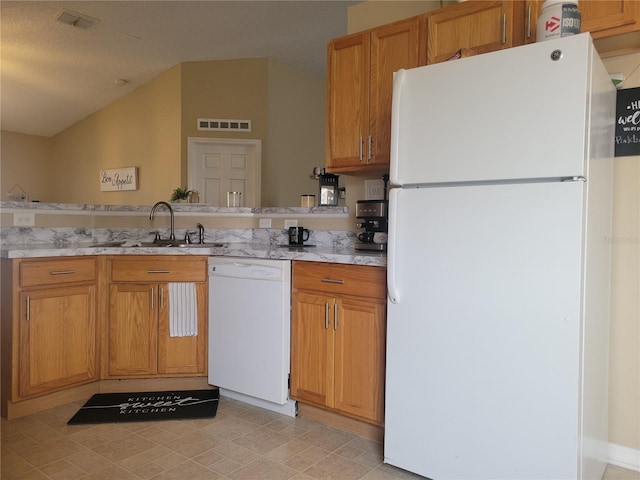 kitchen with sink, a textured ceiling, and white appliances