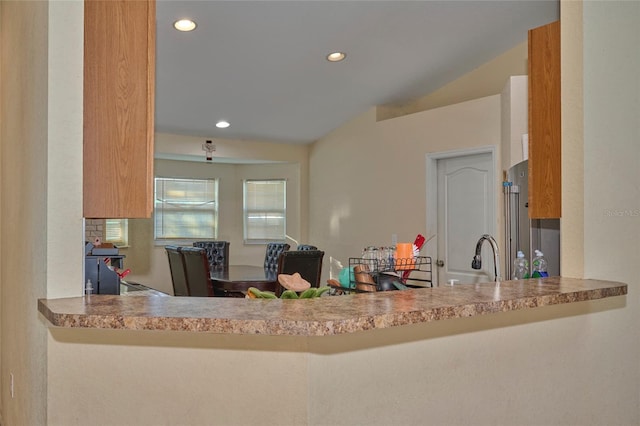 kitchen featuring sink, vaulted ceiling, and high end fridge