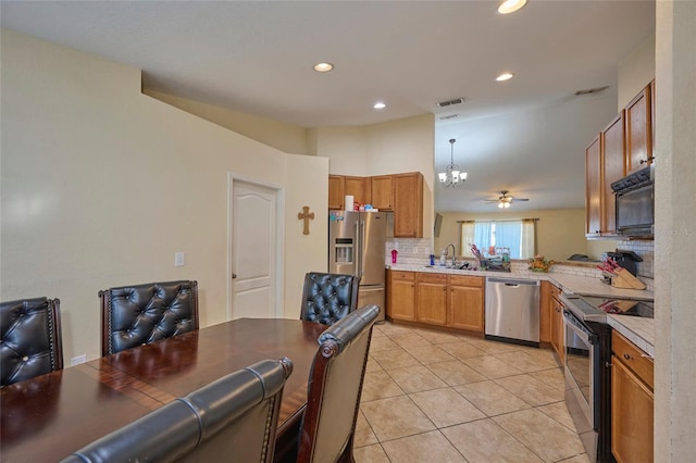 kitchen featuring a notable chandelier, hanging light fixtures, light tile patterned flooring, backsplash, and appliances with stainless steel finishes