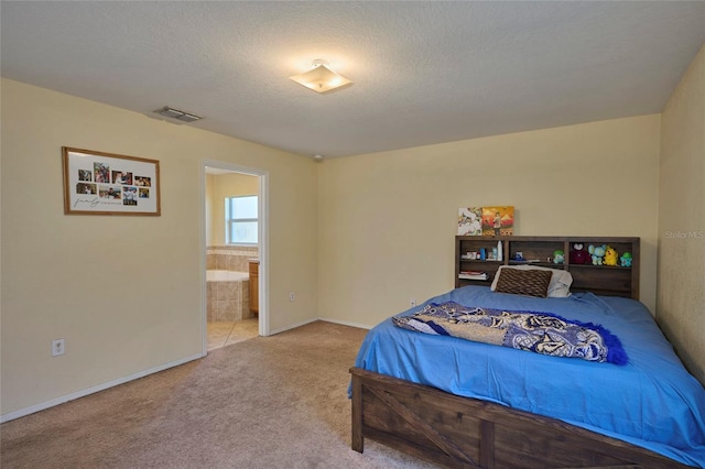 bedroom featuring carpet floors, a textured ceiling, and connected bathroom