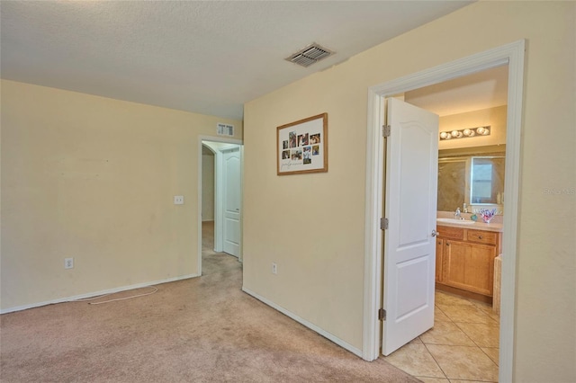 interior space with light colored carpet, a textured ceiling, and sink