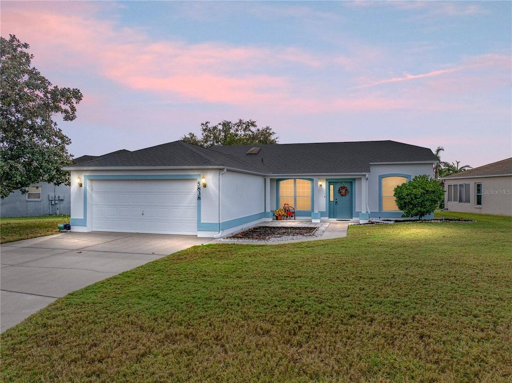 single story home with a lawn and a garage