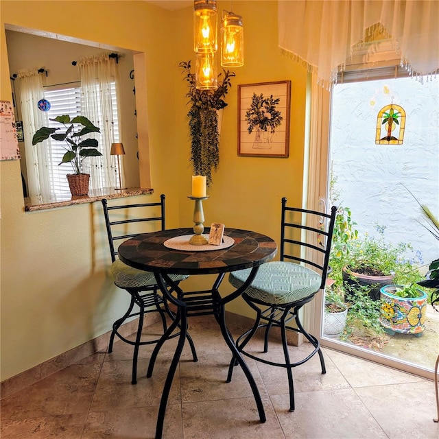 tiled dining room featuring a notable chandelier