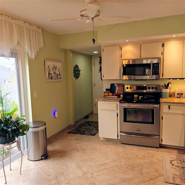 kitchen with white cabinets, ceiling fan, light stone counters, and appliances with stainless steel finishes