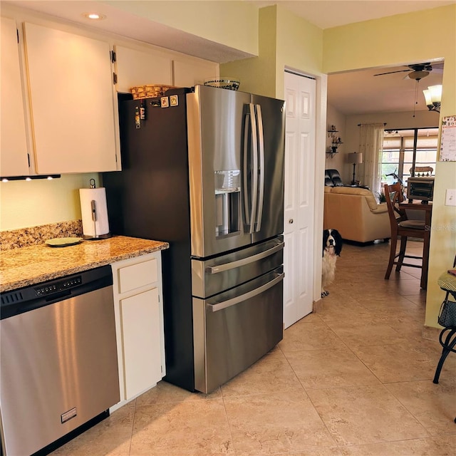 kitchen with white cabinetry, appliances with stainless steel finishes, light stone counters, and ceiling fan