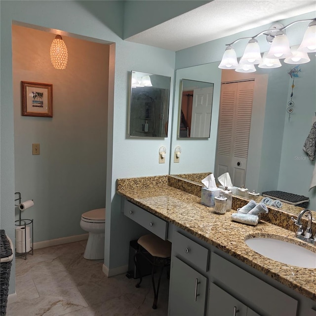 bathroom with vanity, a textured ceiling, and toilet