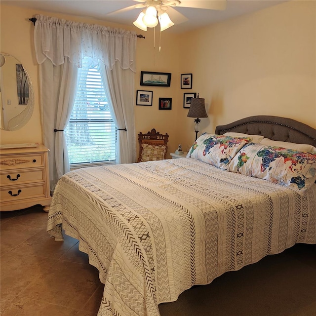 bedroom featuring dark tile patterned flooring and ceiling fan