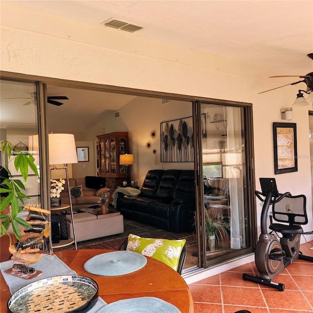 dining room with ceiling fan, tile patterned floors, and vaulted ceiling