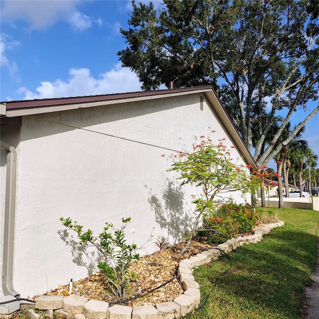 view of side of home with a yard