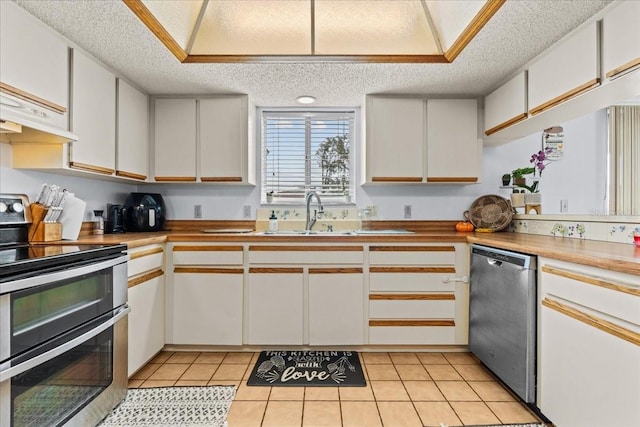 kitchen featuring white cabinetry, stainless steel appliances, a textured ceiling, and sink