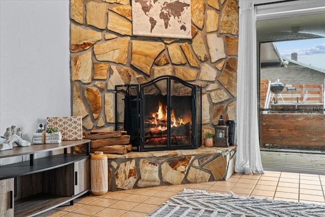 room details featuring a stone fireplace and tile patterned flooring