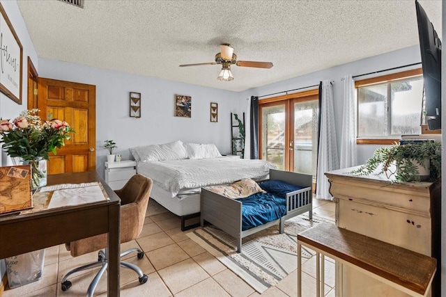 tiled bedroom featuring access to outside, a textured ceiling, ceiling fan, and french doors