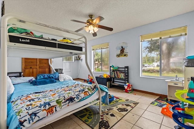 bedroom with light tile patterned flooring, a textured ceiling, and ceiling fan